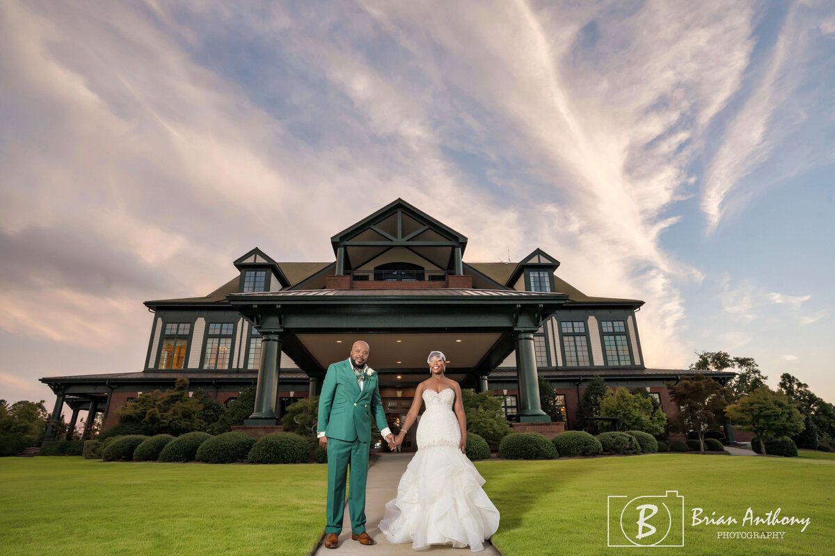 Elegant wedding portrait of the couple posing in front of a luxurious estate.