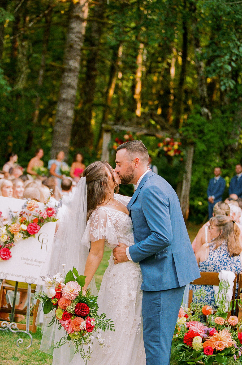 A bride and groom kiss at their outdoor wedding planned by Birdie June Events.