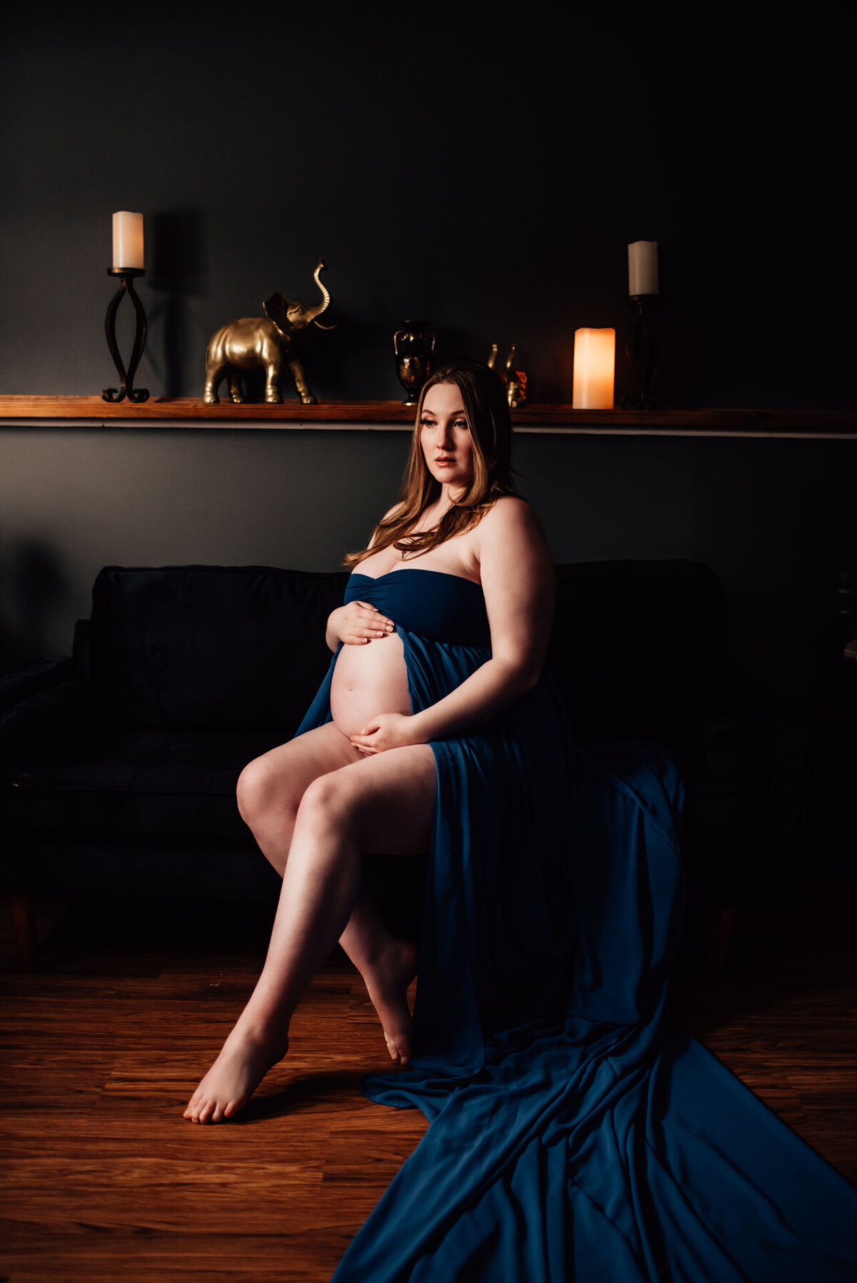 pregnant woman sitting on couch for maternity boudoir photoshoot in ottawa