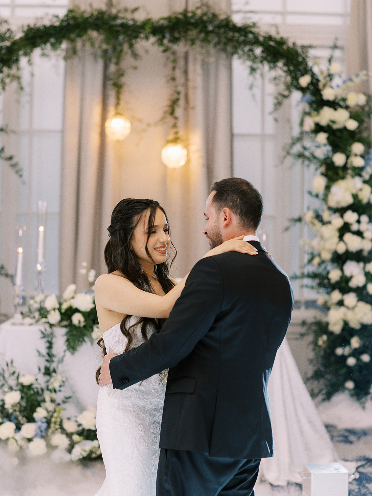 A bride and groom dance together at their Wedding at Fairmont Palliser Calgary, surrounded by floral decorations and soft lighting, creating a classic Calgary wedding atmosphere.