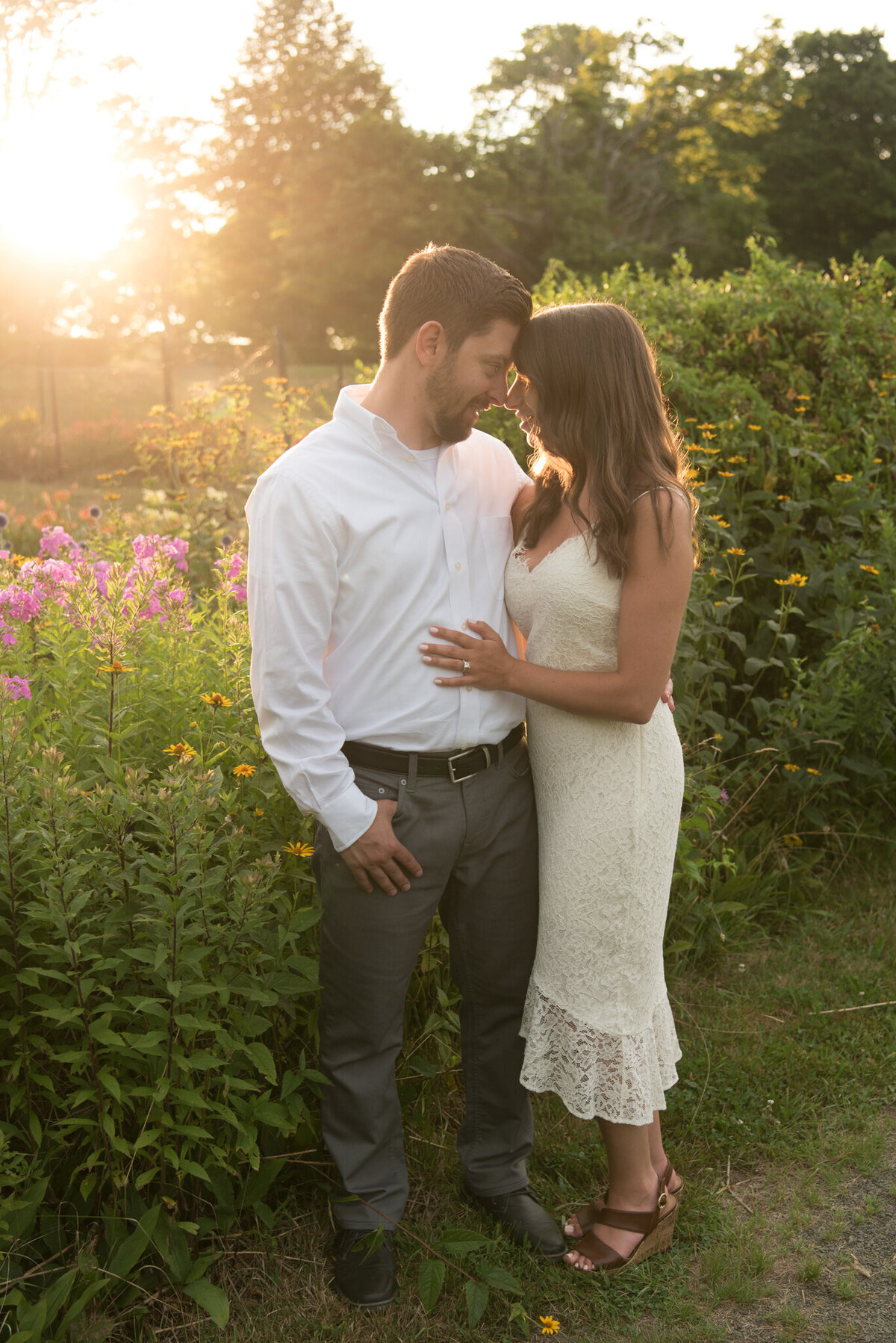 Couple kissing in garden at sunset