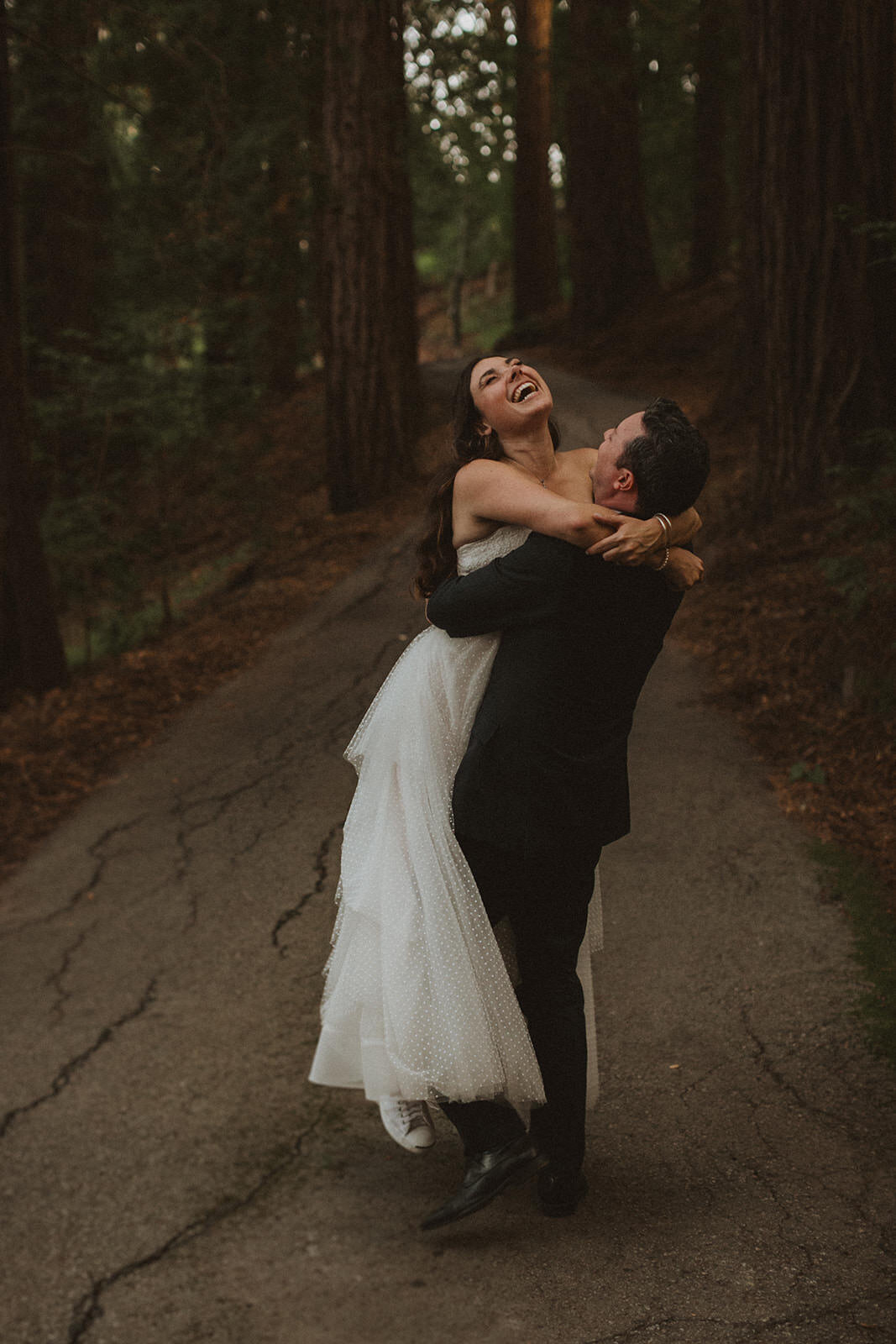 bride and groom embracing on trail