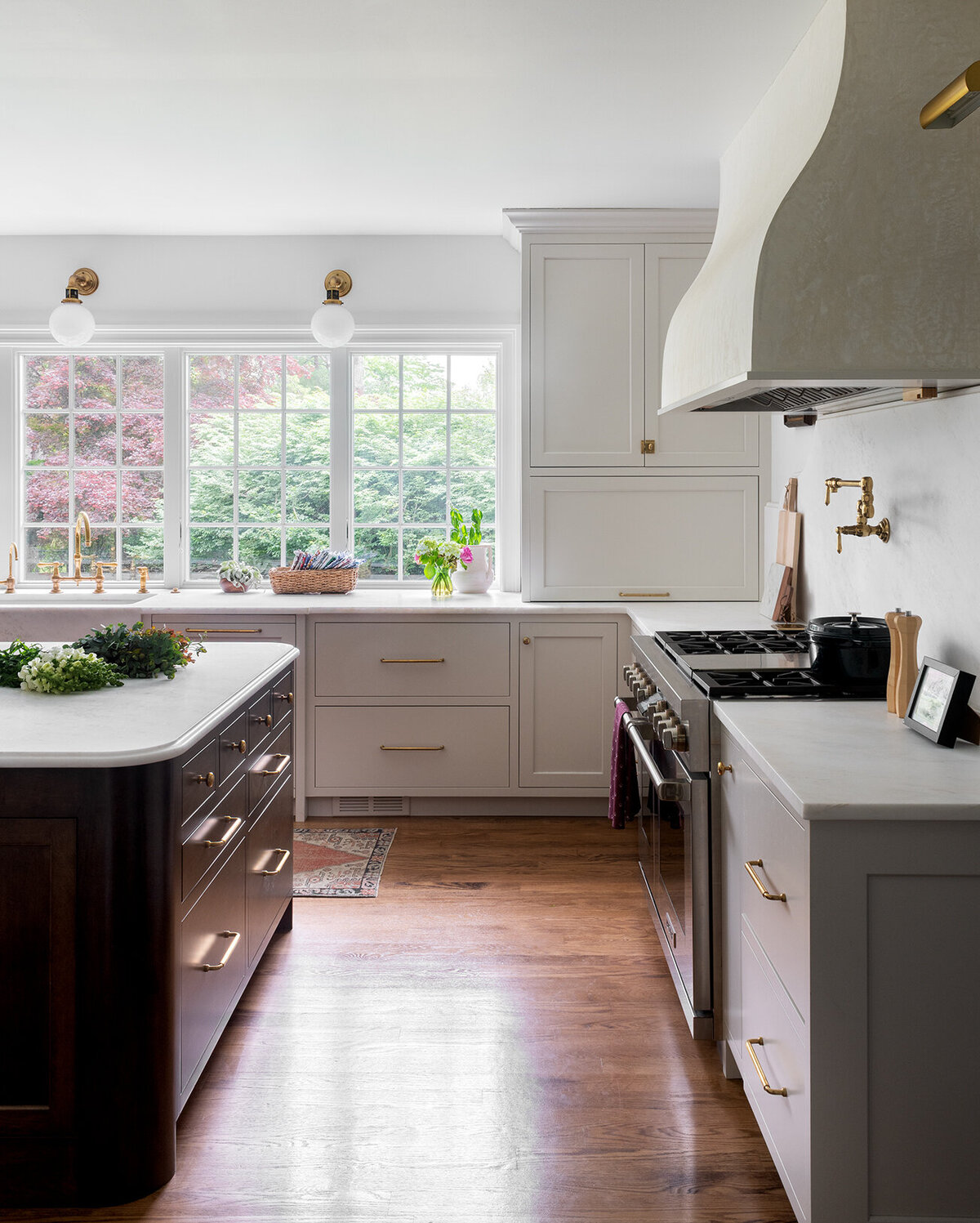 bright white kitchen with stove top  and large windows