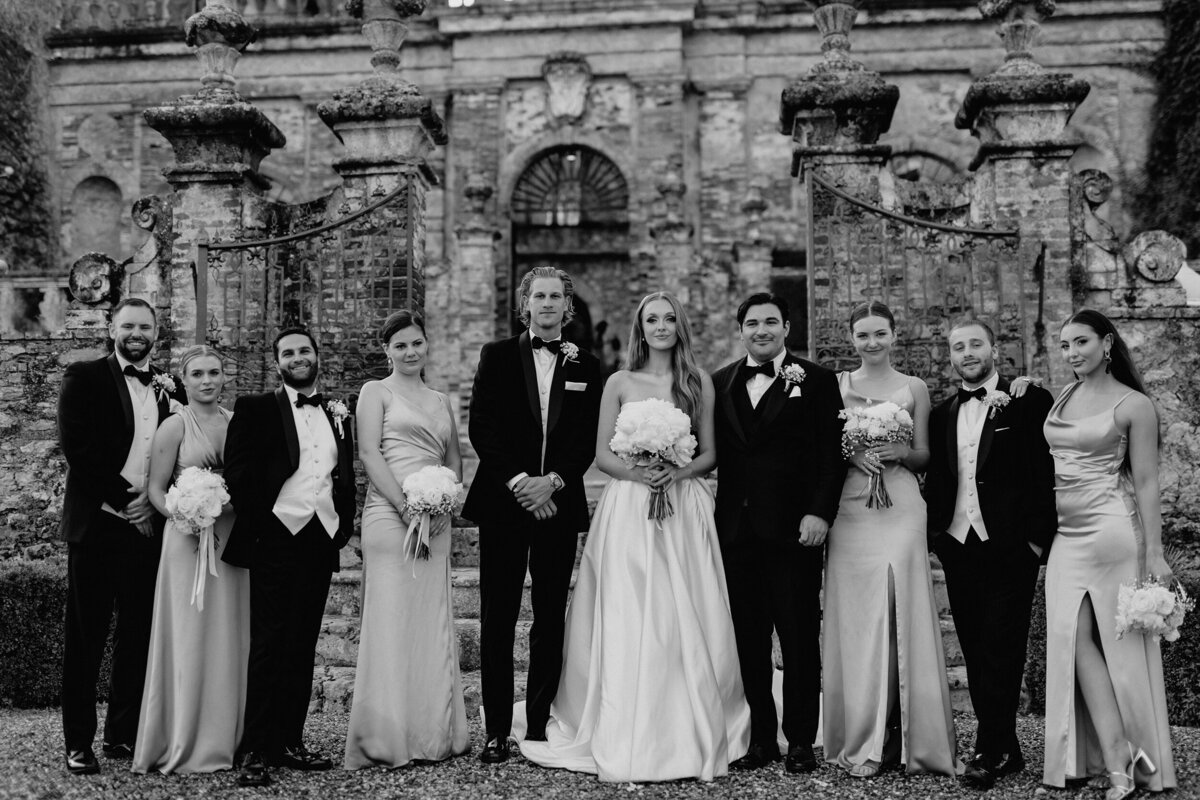 Bridal party portrait in front of castle in Tuscany