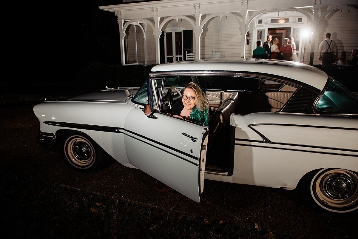 Mahlia sitting in a vintage car outside Cool Springs House