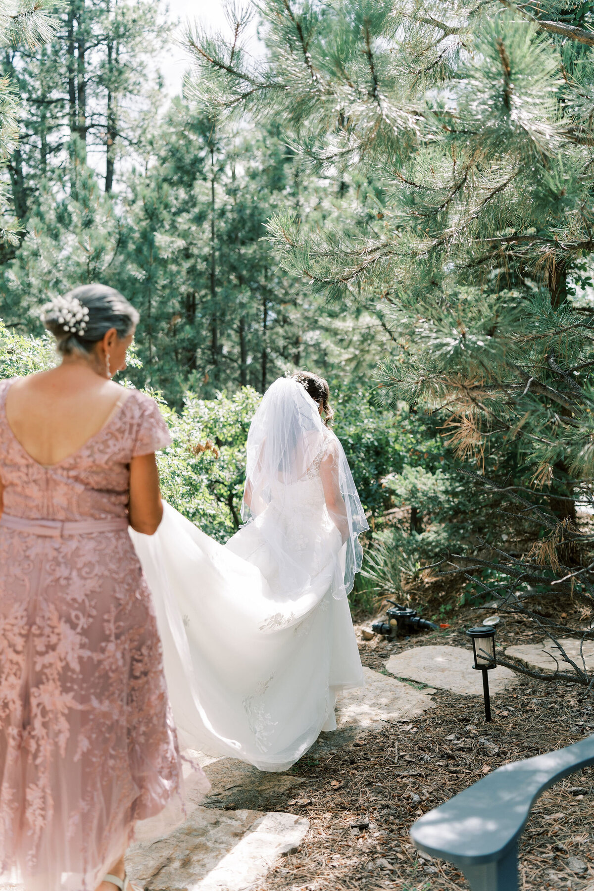 mom carries daughters dress down the aisle