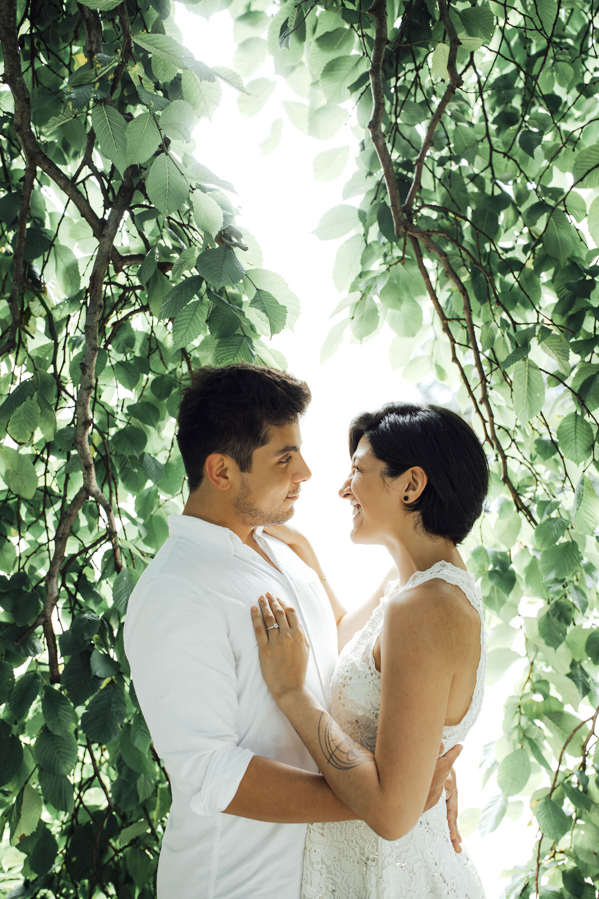 Couple among vines with lights during engagement session at Grounds for Sculpture in Hamilton Township New Jersey