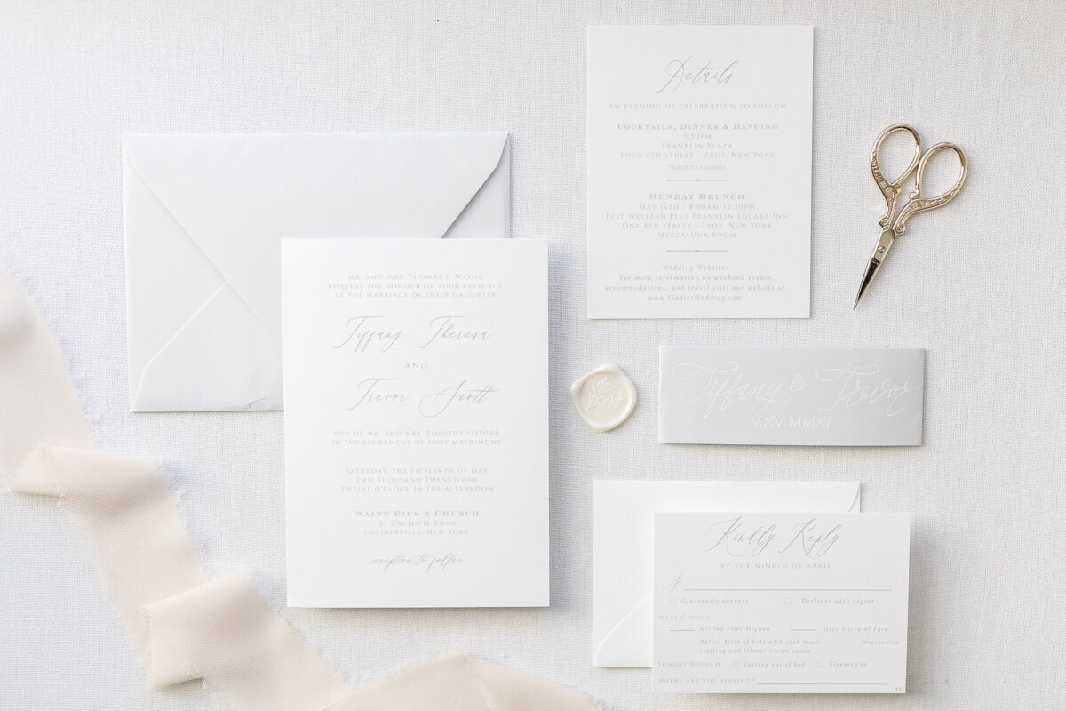 Elegant white, grey and gold invitation suite flat lay for a wedding at Franklin Plaza in Troy, NY