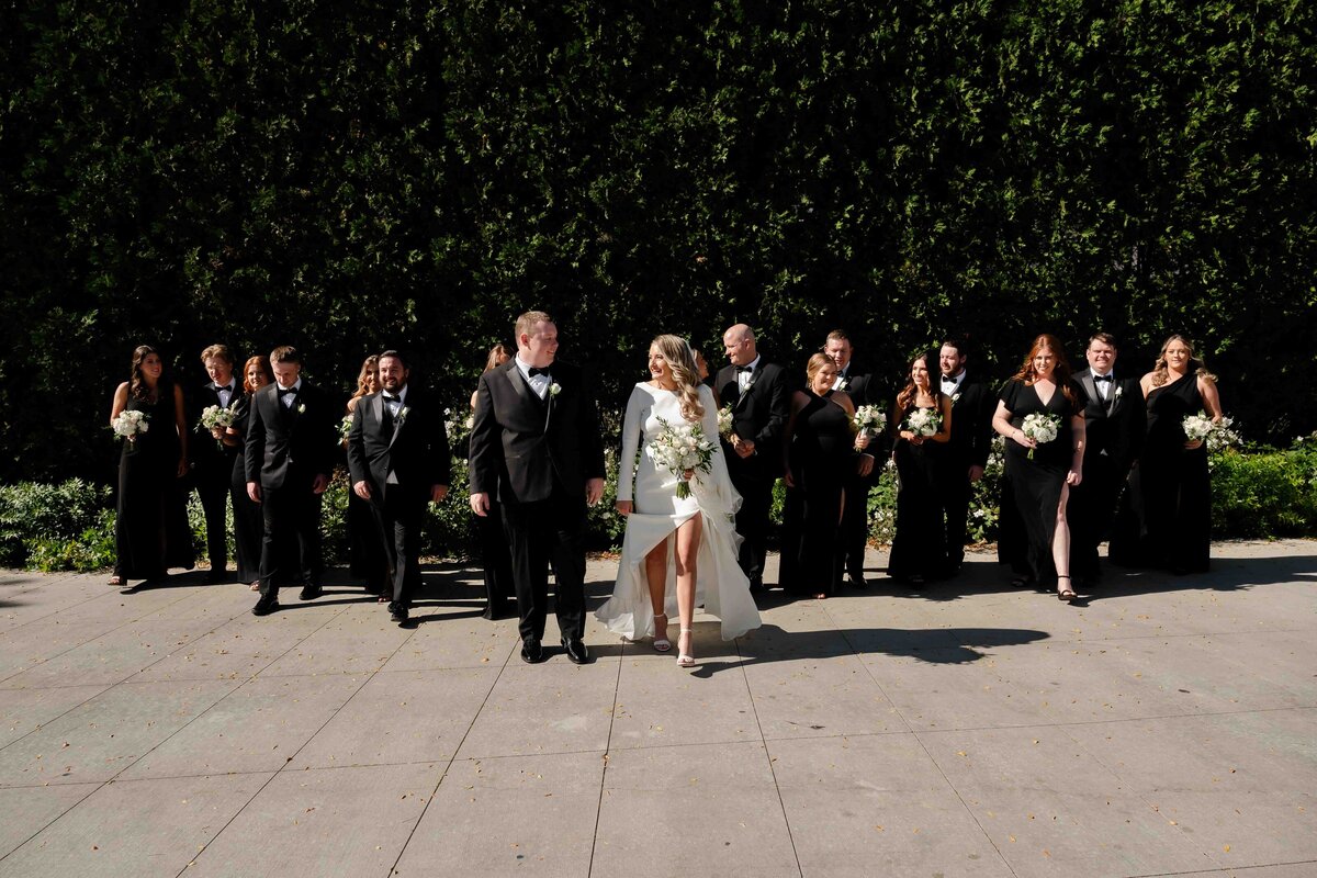 Wedding party walks with bride an groom at Lurie Garden