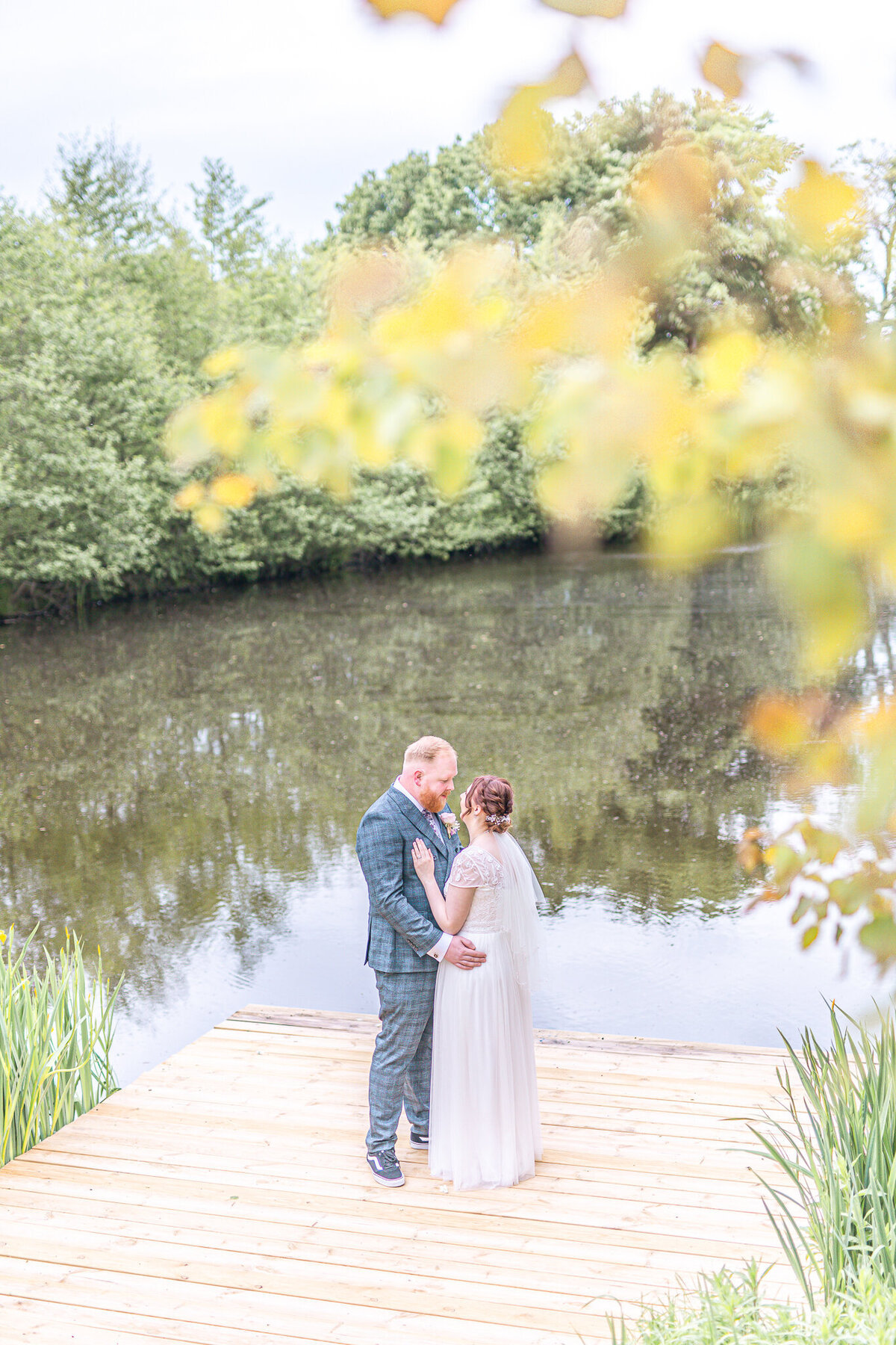Bride and groom standing in front of the lake at Styal Lodge Cheshire