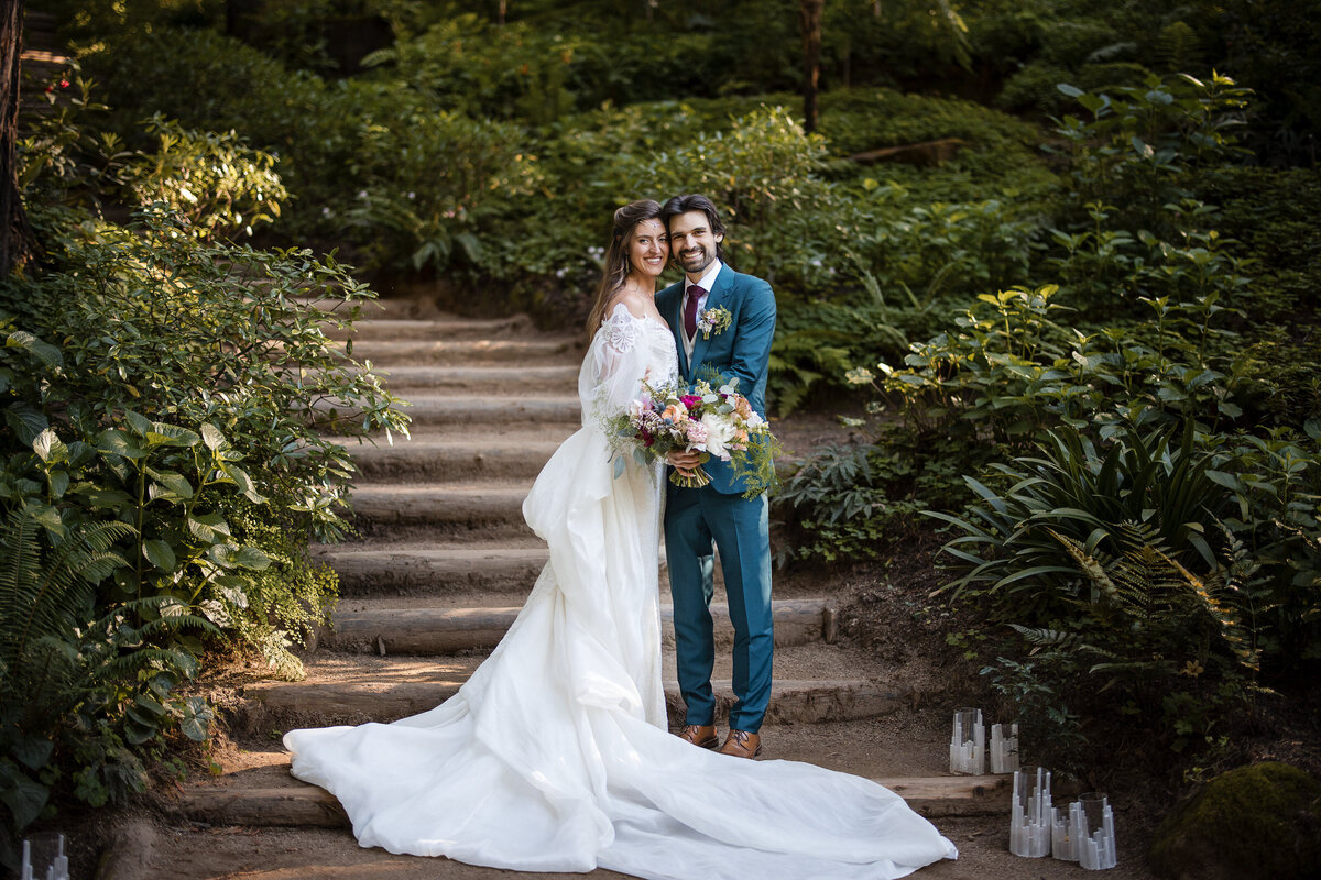 A couple poses on the staircase at a destination wedding at Nestldown in Los Gatos, California