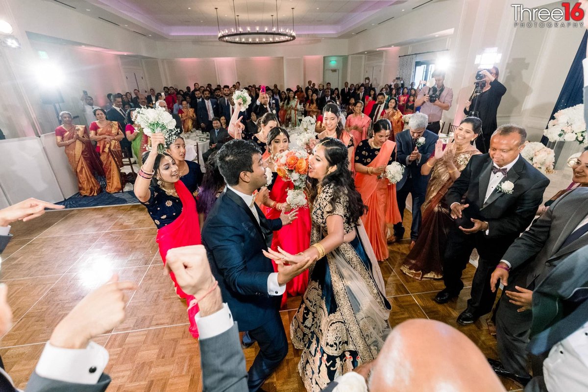 Bride and Groom dance together at wedding reception and all the guests cheer them on