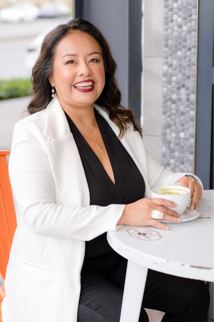 Katty smiling with a cup of tea in a cozy, cheerful moment. Perfect for personal branding photoshoots focused on tea culture, daily rituals, and joyful interactions.