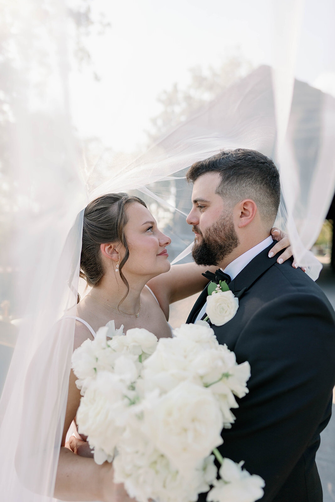 Romantic bride and groom portrait under the wedding veil at Dearborn Village Michigan, soft natural light.