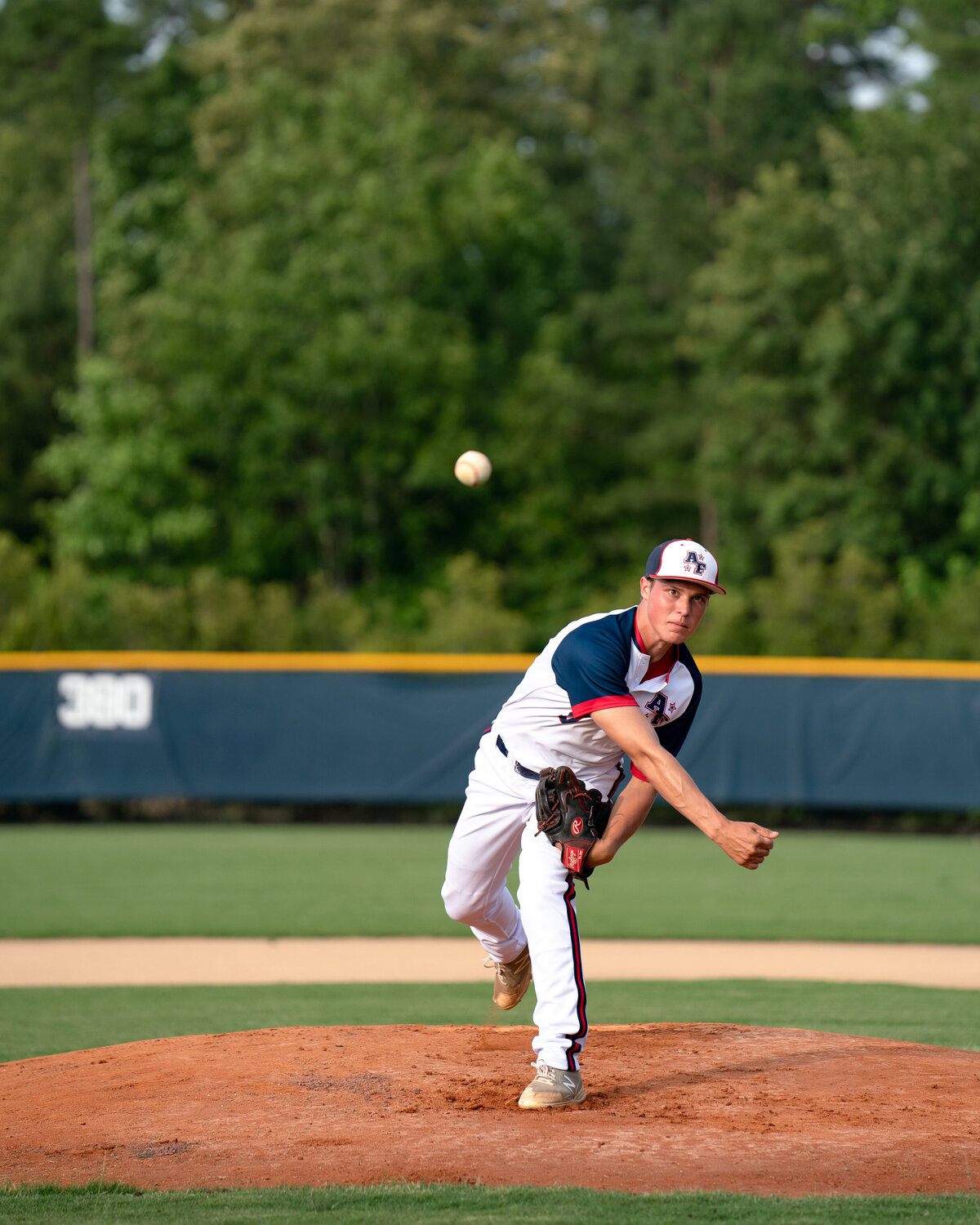 Expressive portrait of Connor Resavy throwing baseball towards camera. Captured at Apex-Friendship High School in Spring 2020