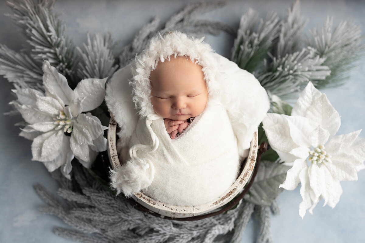 Close-up of a baby wrapped in white fur and swaddle during winter newborn photography session by Dallas newborn photographer.