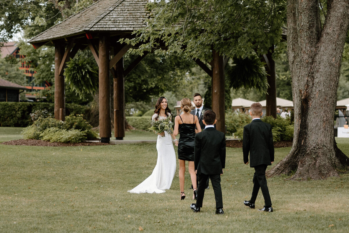 The bride smiling as her children comes up to her to say their congratulations
