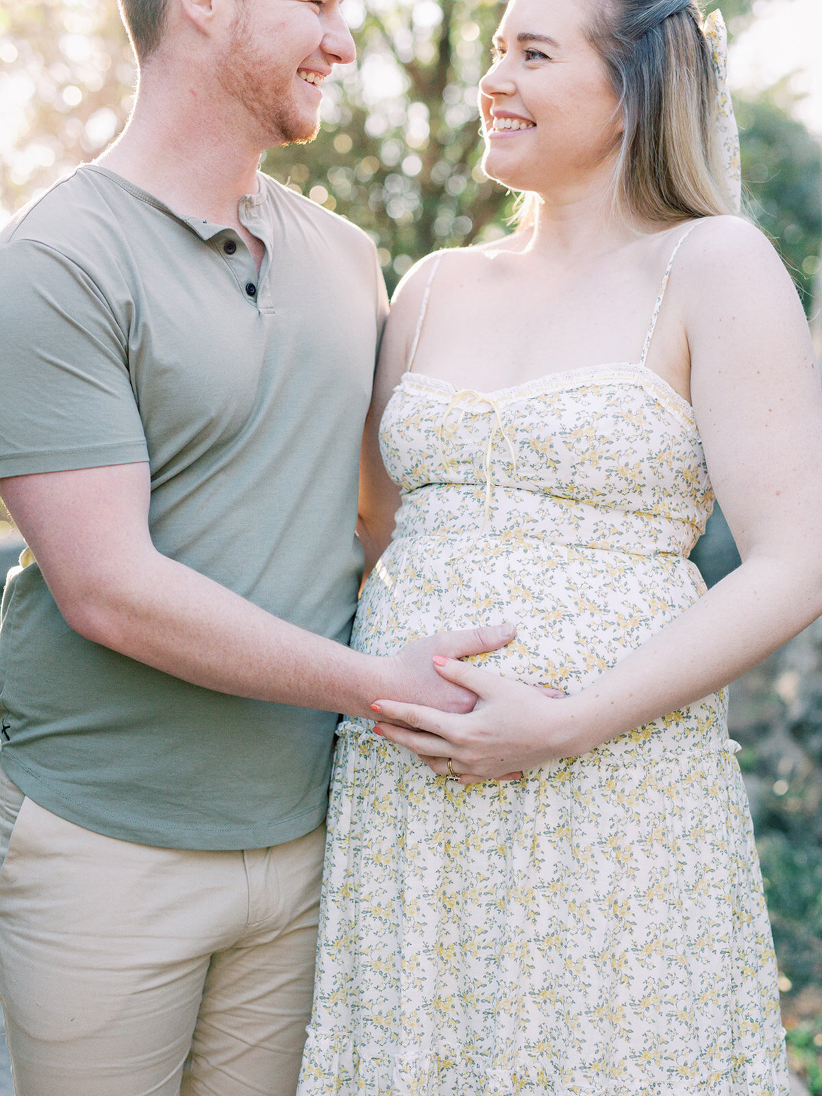 A close-up of a couple holding the mother's pregnancy bump during a Richmond maternity photography session by Katie Stansfield Photography.