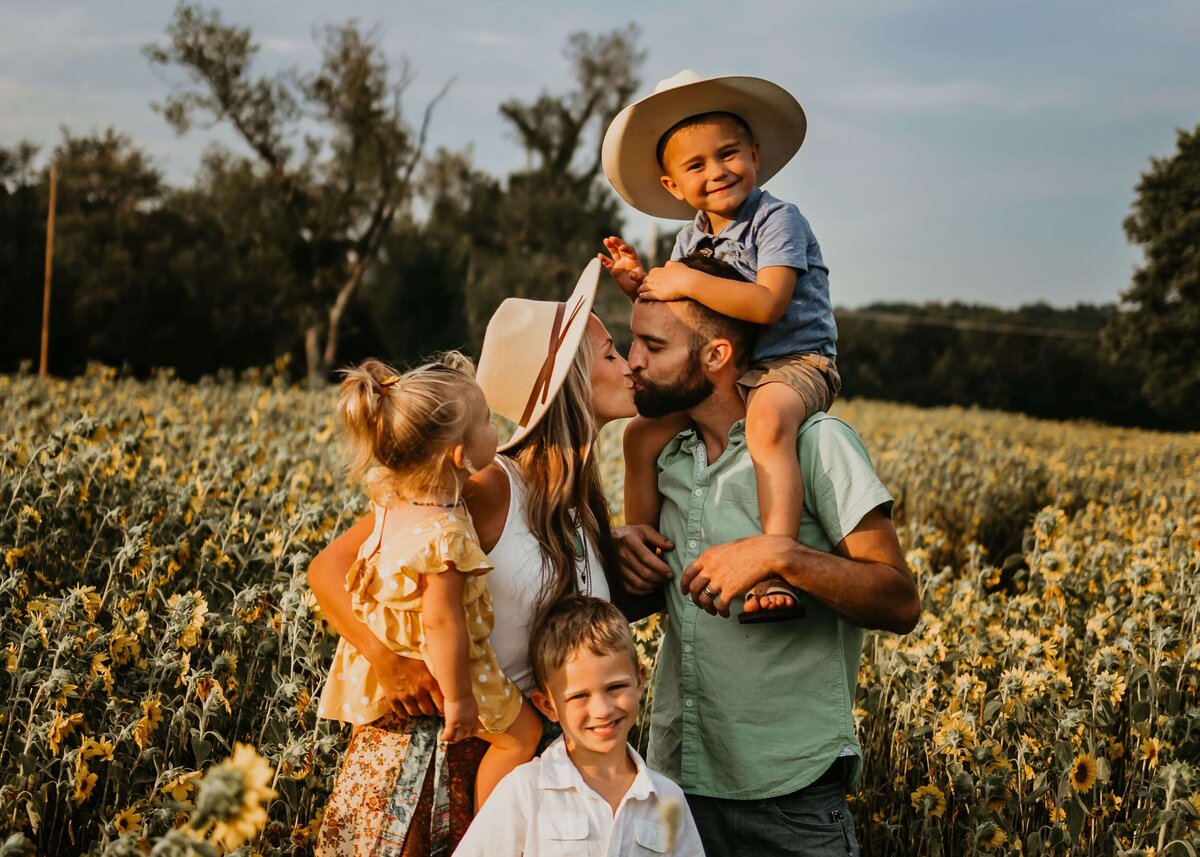 A Pittsburgh family photographer captures a family standing in a field of sunflowers.