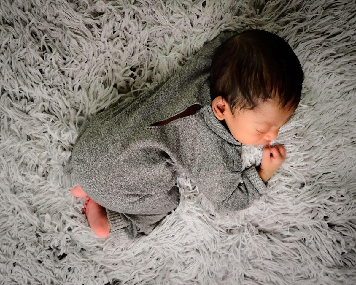 An overhead view of a newborn sleeping on his tummy during his newborn photo session in Kitsap County, WA.