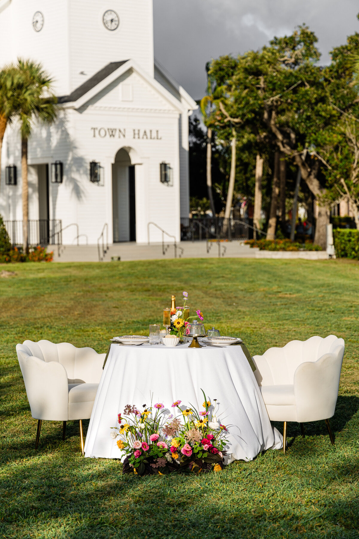 elopement table set up of white and beige with wildflowers in front of farmhouse styled town hall