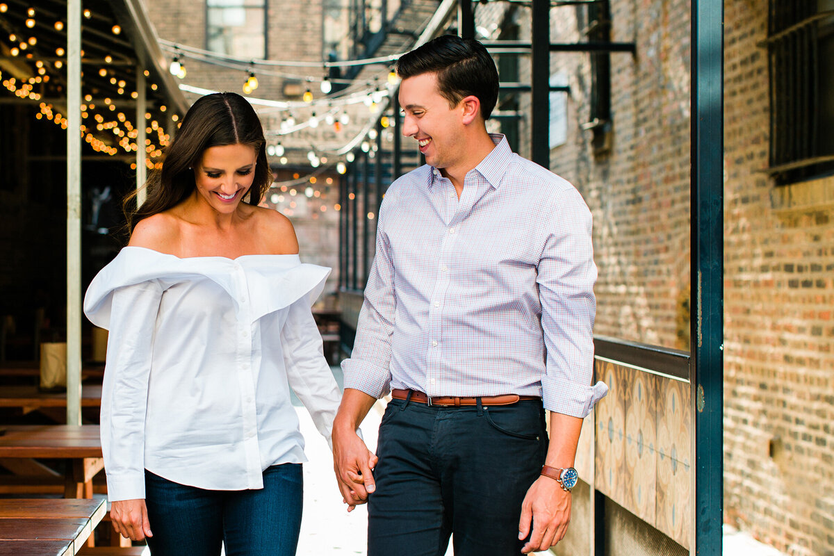 A West Loop engagement photo with string lights overhead