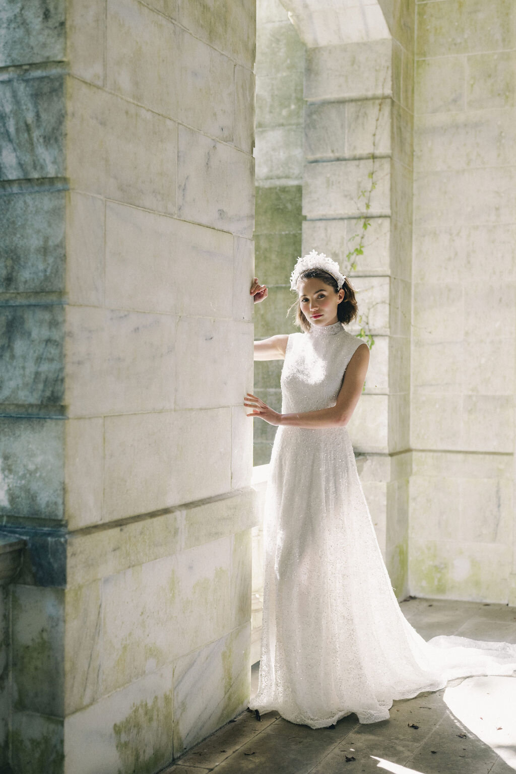 bride leaning on mansion column