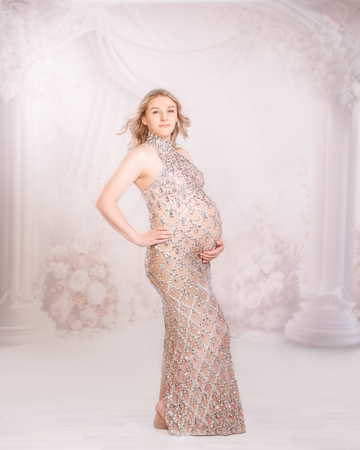 Classic studio maternity portrait with a flowing white gown, captured in Overland Park, Kansas. Perfect for expectant mothers seeking timeless maternity photography in the Kansas City metro area