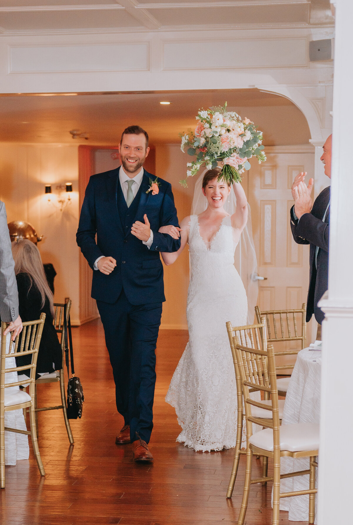 Newlyweds smile surrounded by family