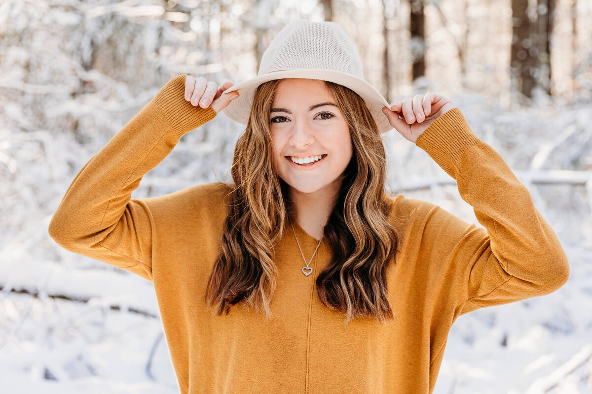 adorable senior girl playing with her hat during her senior photography session