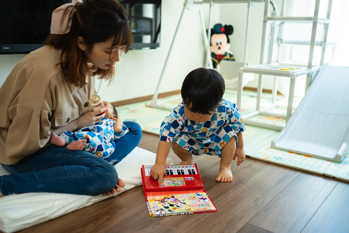 ピアノのおもちゃ絵本で遊んでいる親子