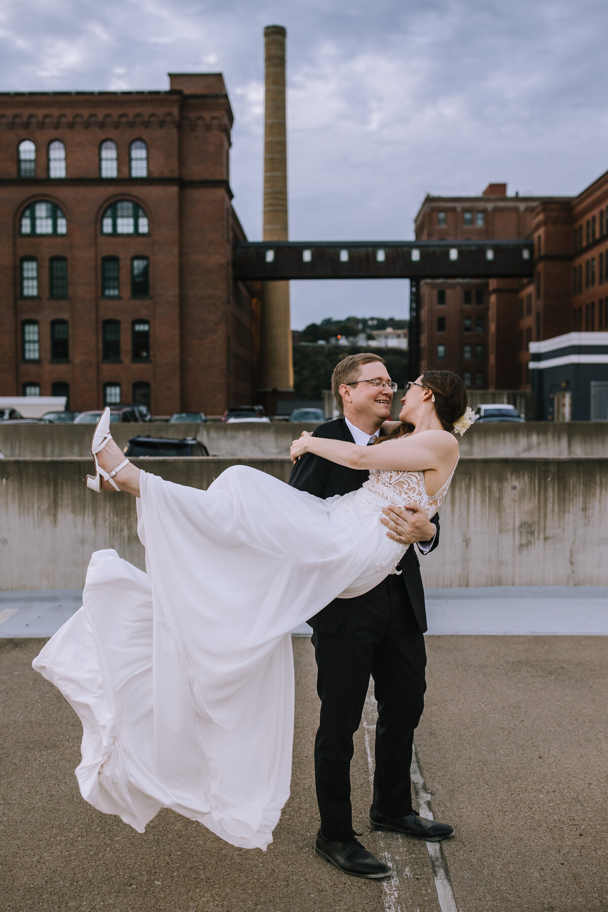 Groom lifting up bride on rooftop by the Heinz Lofts.