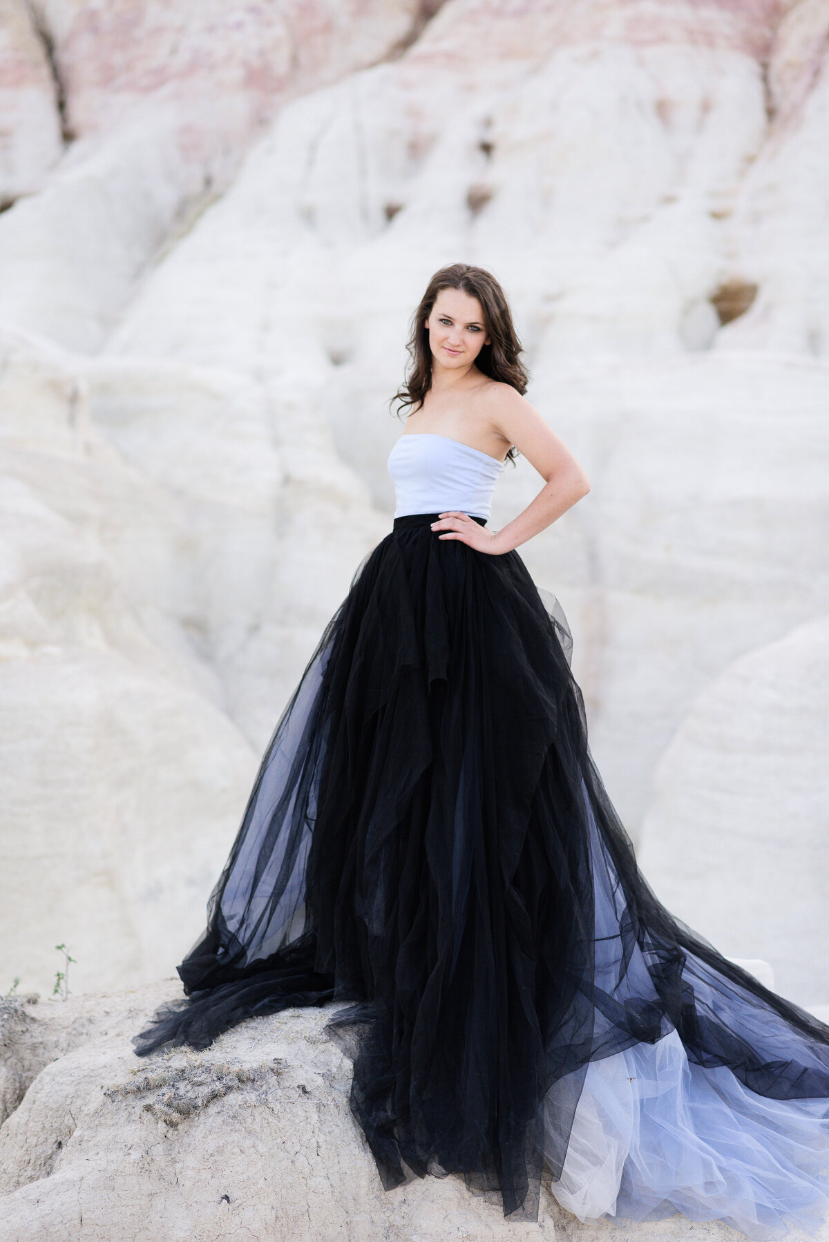senior photo outfit ideas with high school senior girl in a white and black tulle gown in a large white rock with a hand on her hip taken by denver senior photographer