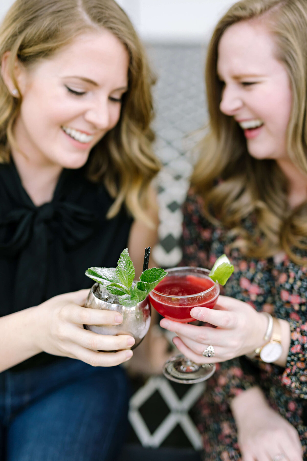 Two people holding cocktails