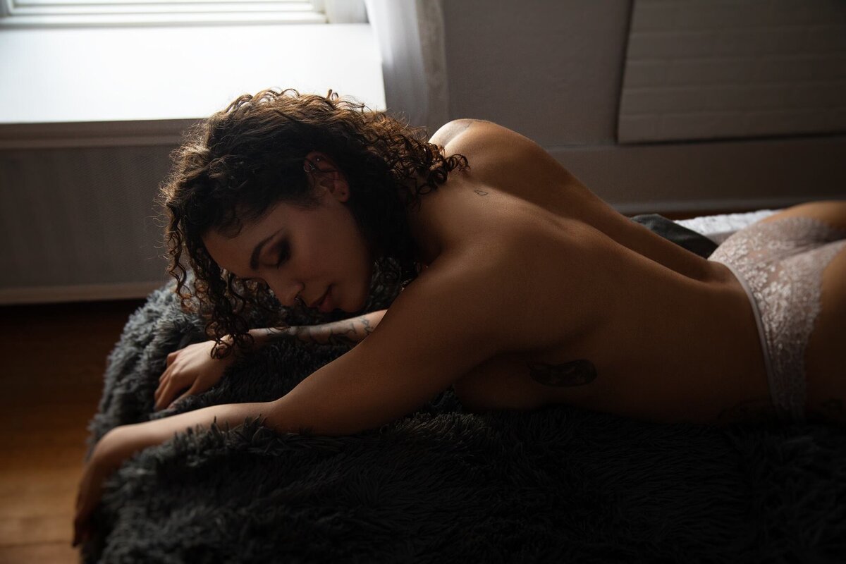 Woman laying on bed with moody light