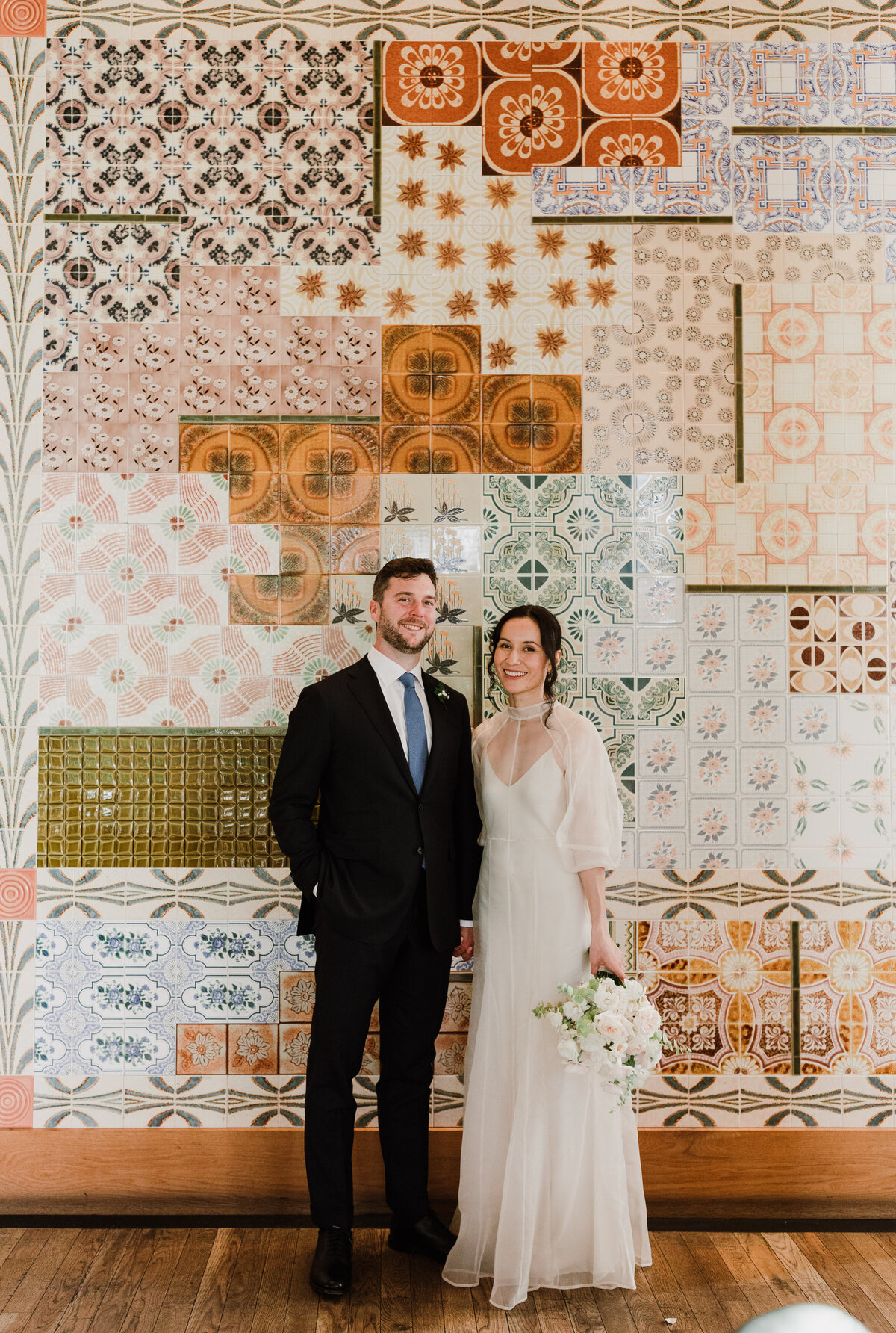 Bride and groom standing infront on pattered backdrop at Proper Hotel wedding in Austin