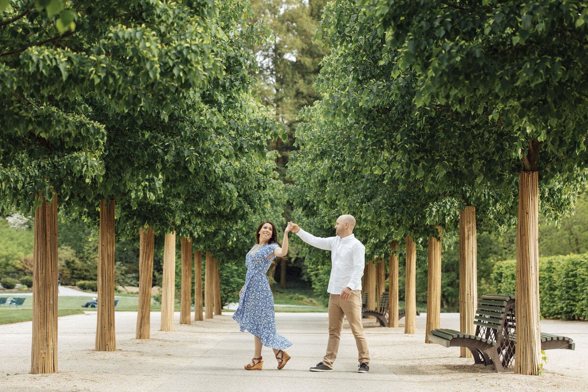 Couple dancing among tall trees during engagement session at Longwood Gardens in Kennett Square Pennsylvania