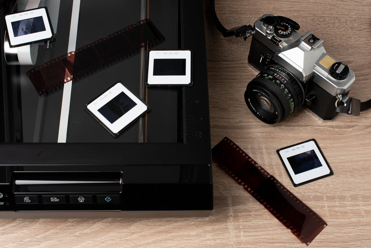 A collection of old photo slides scattered on a table, prepared for digital scanning and preservation.