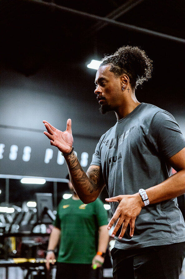 Coach at Kula Sports Performance demonstrates proper arm form for sprinting.