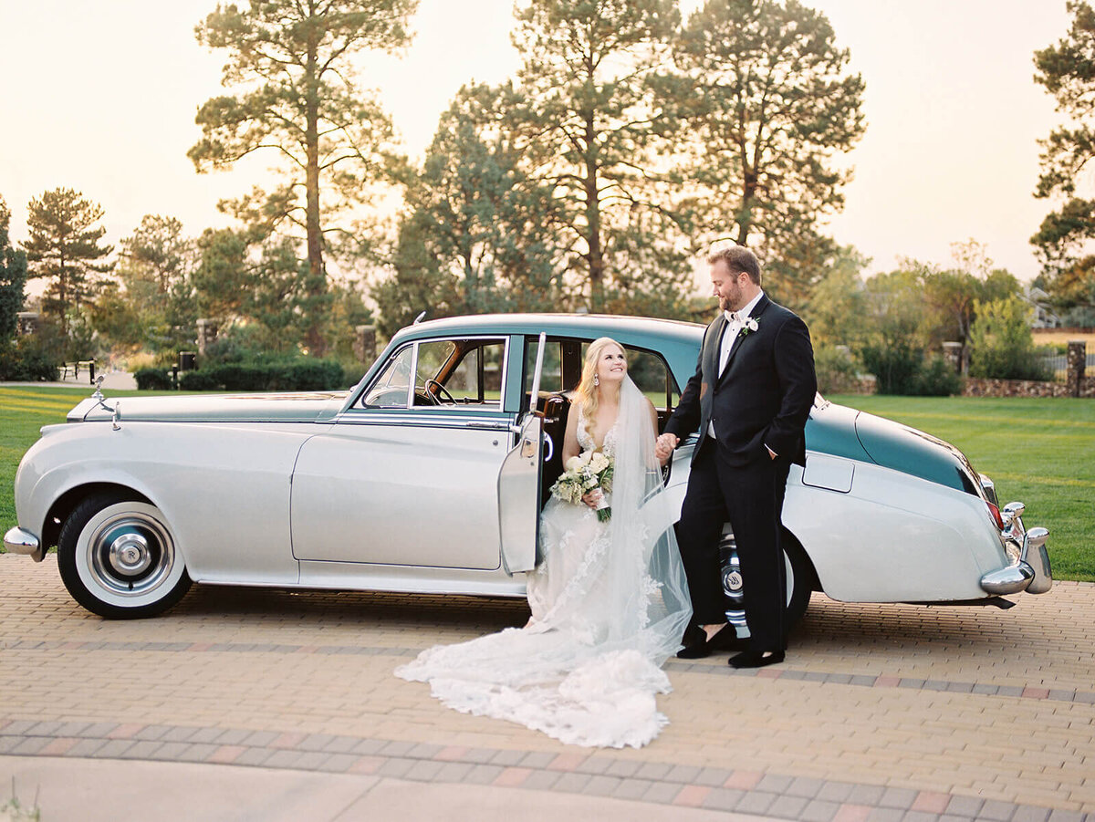 Bride stepping out of a classic car in Colorado