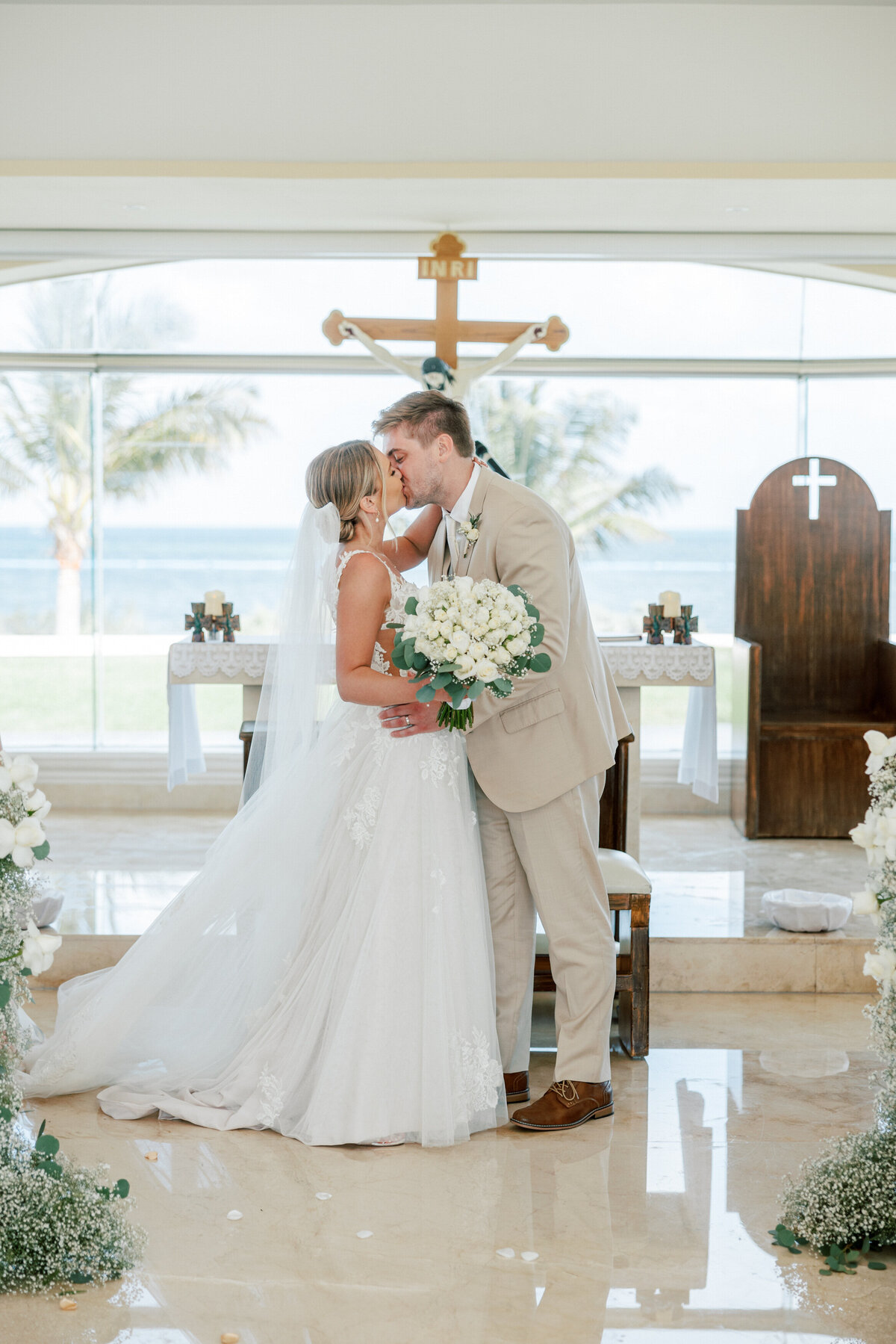 Bride and groom kiss in chapel after vows at Cancun wedding, by Philadelphia-based wedding photographer.