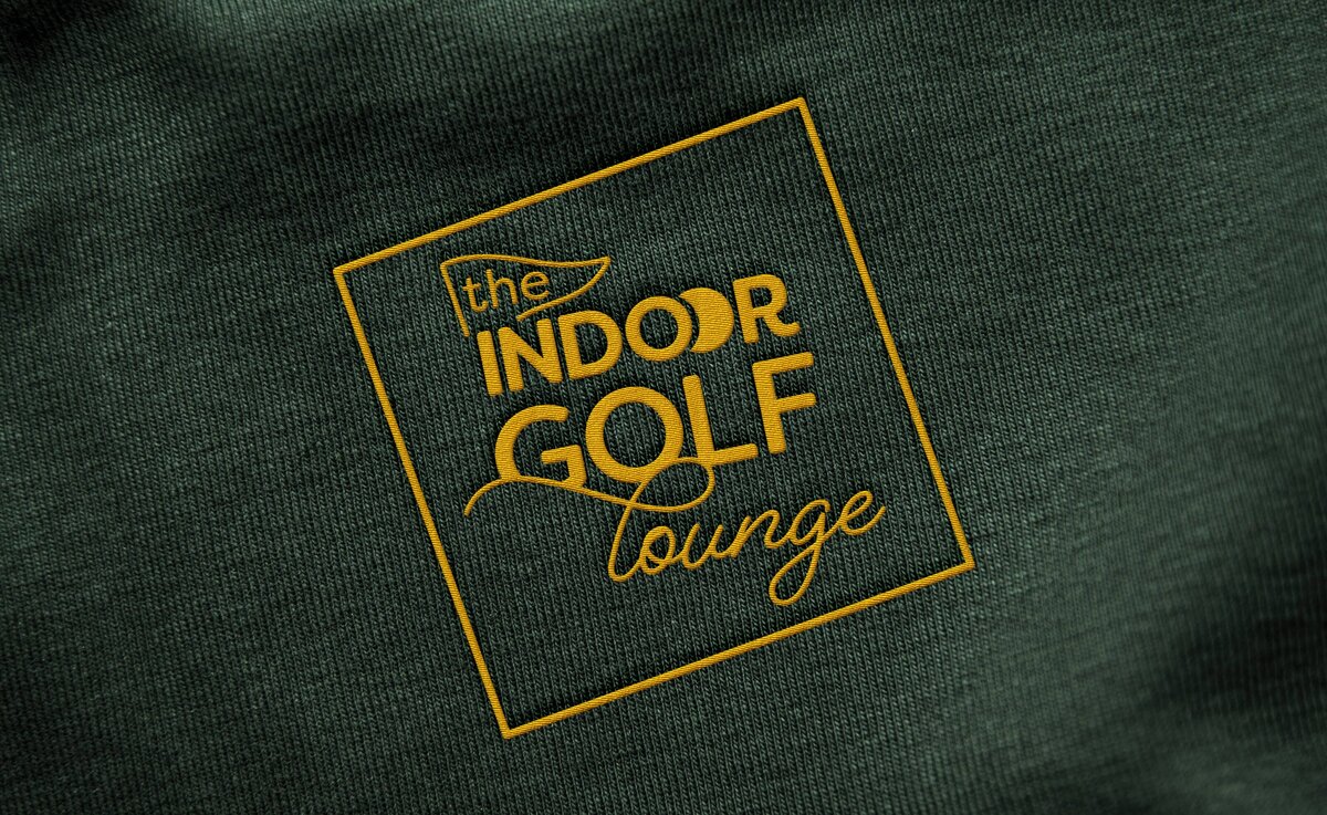 A yellow logo embroidered onto dark green fabric