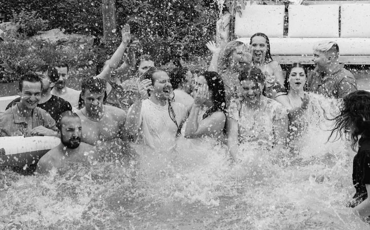 Bride and groom jump into the pool with all of their friends after their surprise wedding in Boulder and splash around candidly