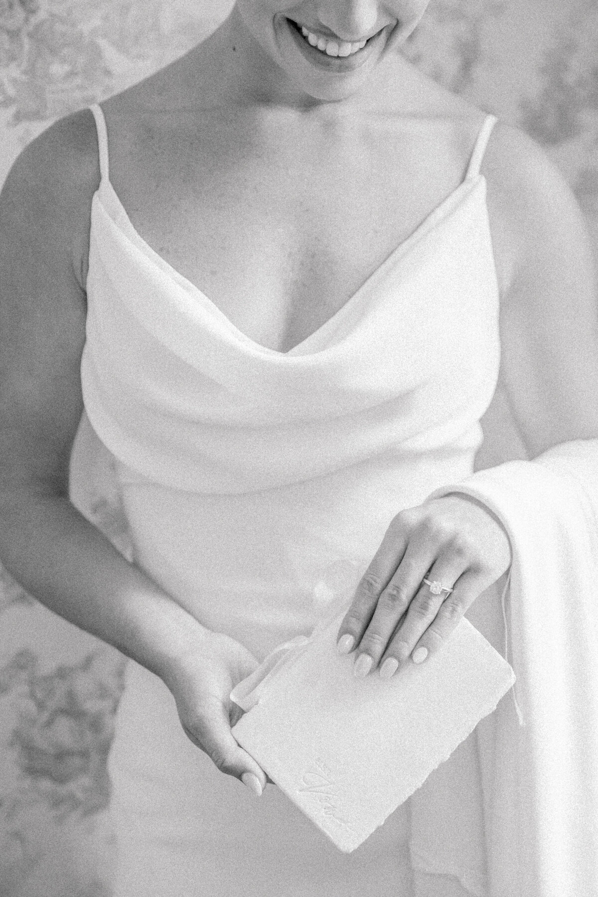 A black and white image of a bride holding her vow book in the bridal suite at Rust Manor House