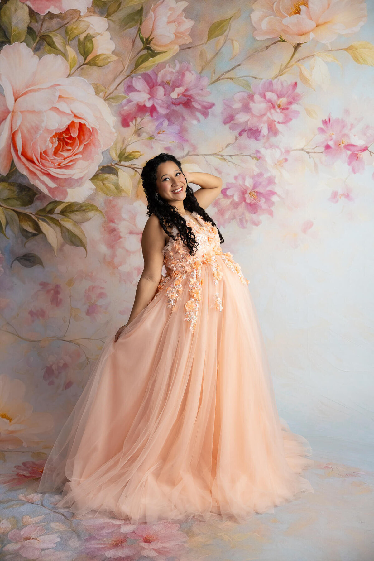 Pregnant mother in couture gown standing gracefully in studio light
