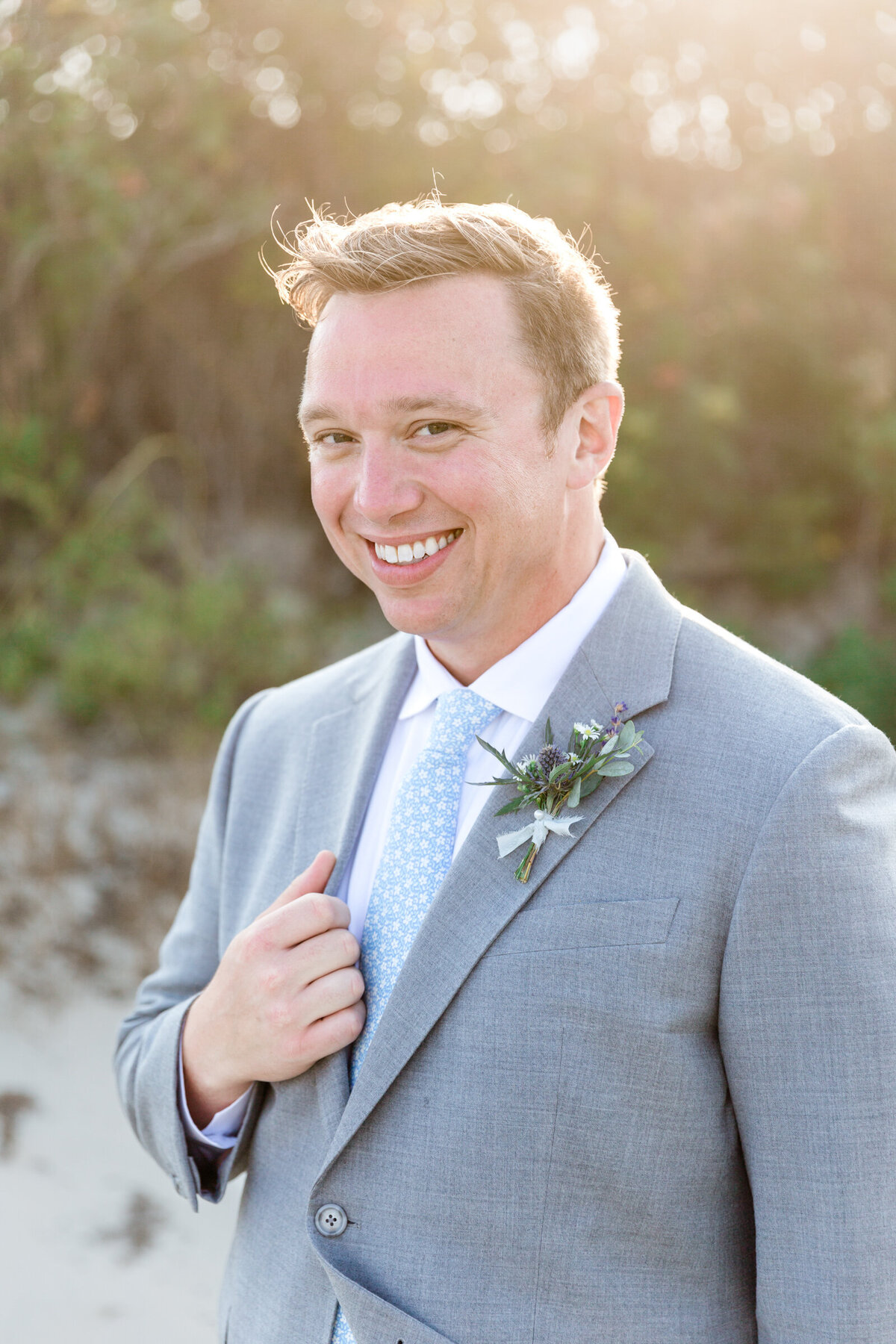 A groom in a light gray suite and light blue tie