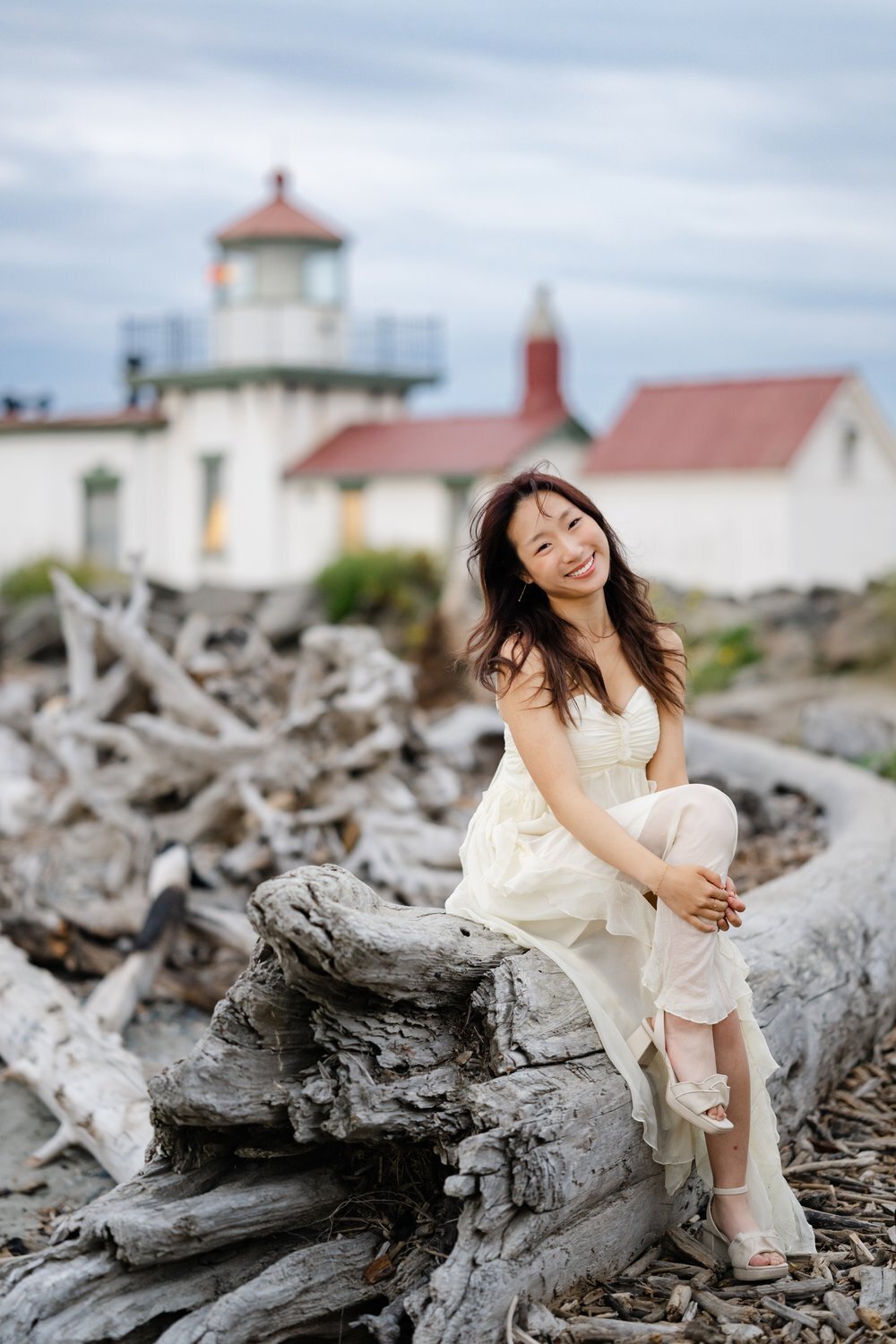 kirkland senior seated on driftwood by discovery park lighthouse