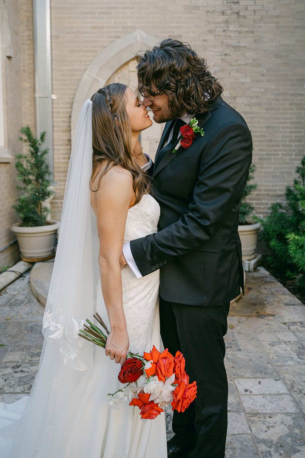 Bride and groom pose on neutral stone stairs at historic San Antonio estate for classic editorial moment