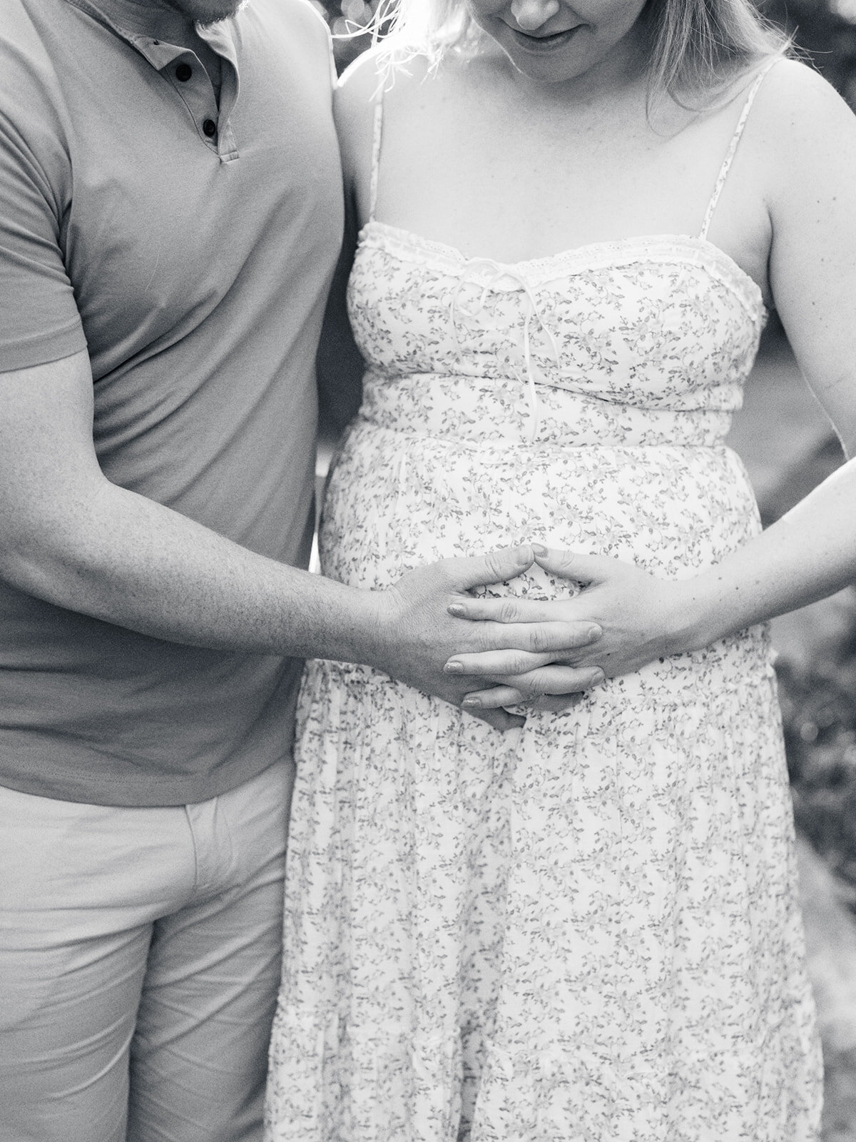 A close-up of a couple holding the mother's pregnancy bump during a Richmond maternity photography session by Katie Stansfield Photography.