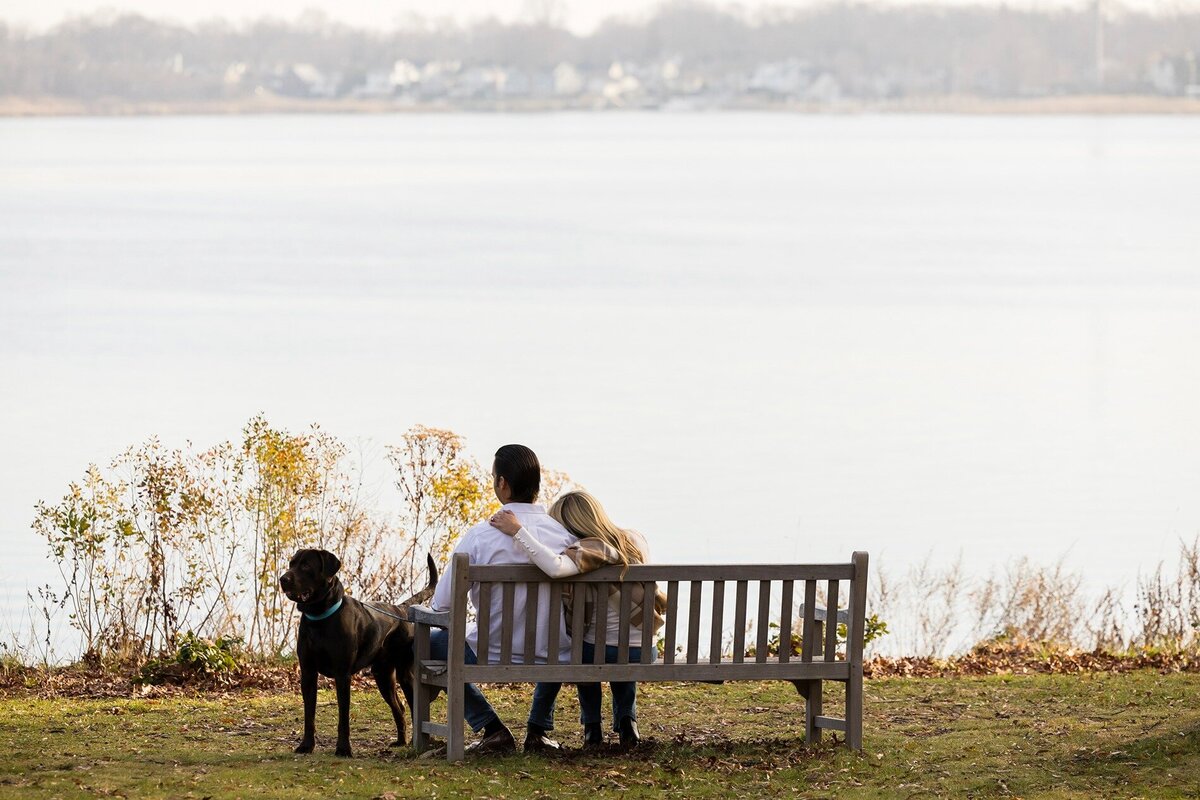 engaged-couple-with-dog-on-bench